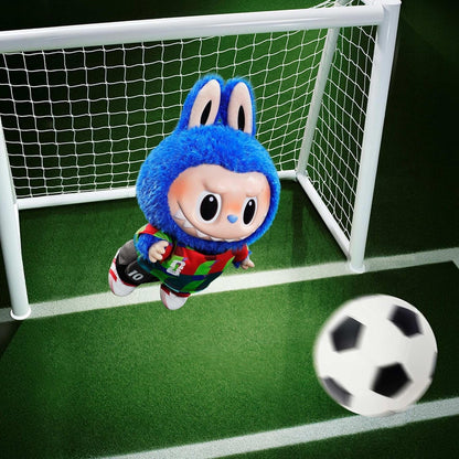 Plush toy character in a soccer uniform kicking a ball towards a goal.