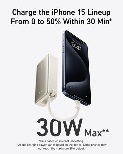 Anker Nano Power Bank in black with built-in USB-C cable, 30W portable charging device on a stone surface.