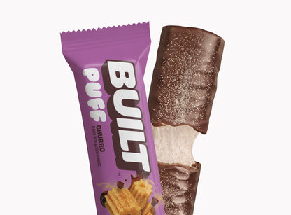 Built BUILT Churro Puff, a snack with a crispy puff pastry exterior and cinnamon sugar filling, shown in a close-up image.