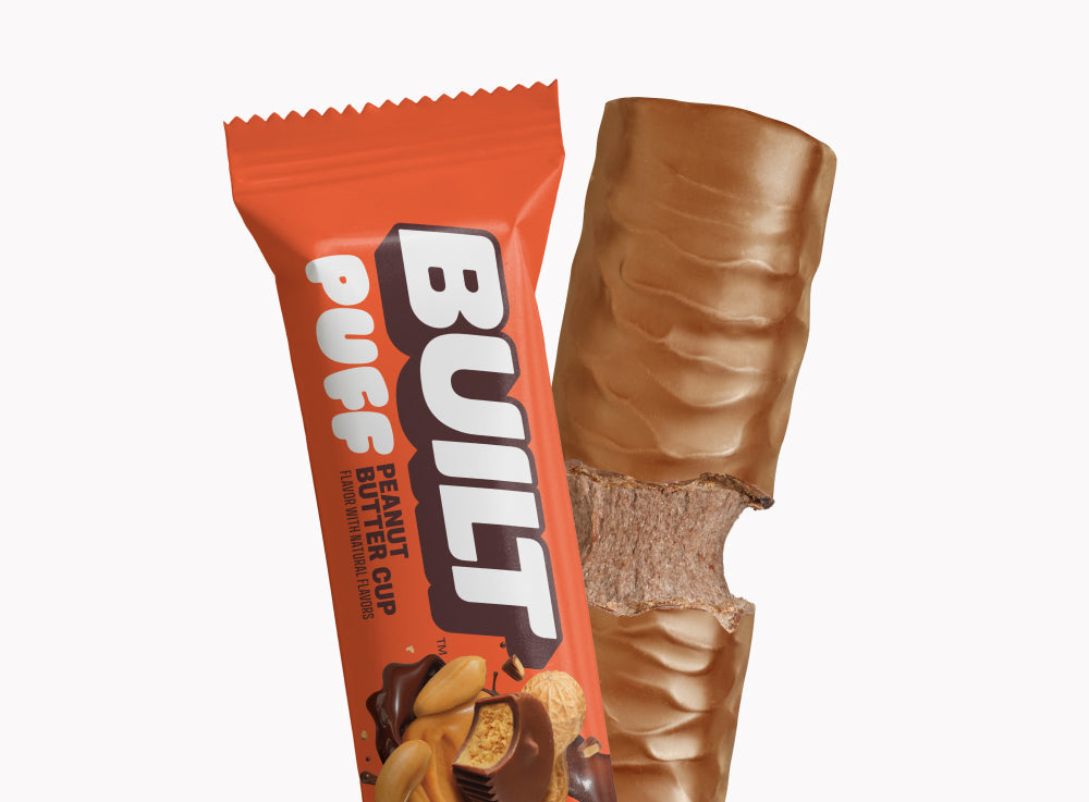 BUILT Peanut Butter Cup Puff, soft puffs filled with peanut butter, in a clear bag, showing the snack's creamy interior.