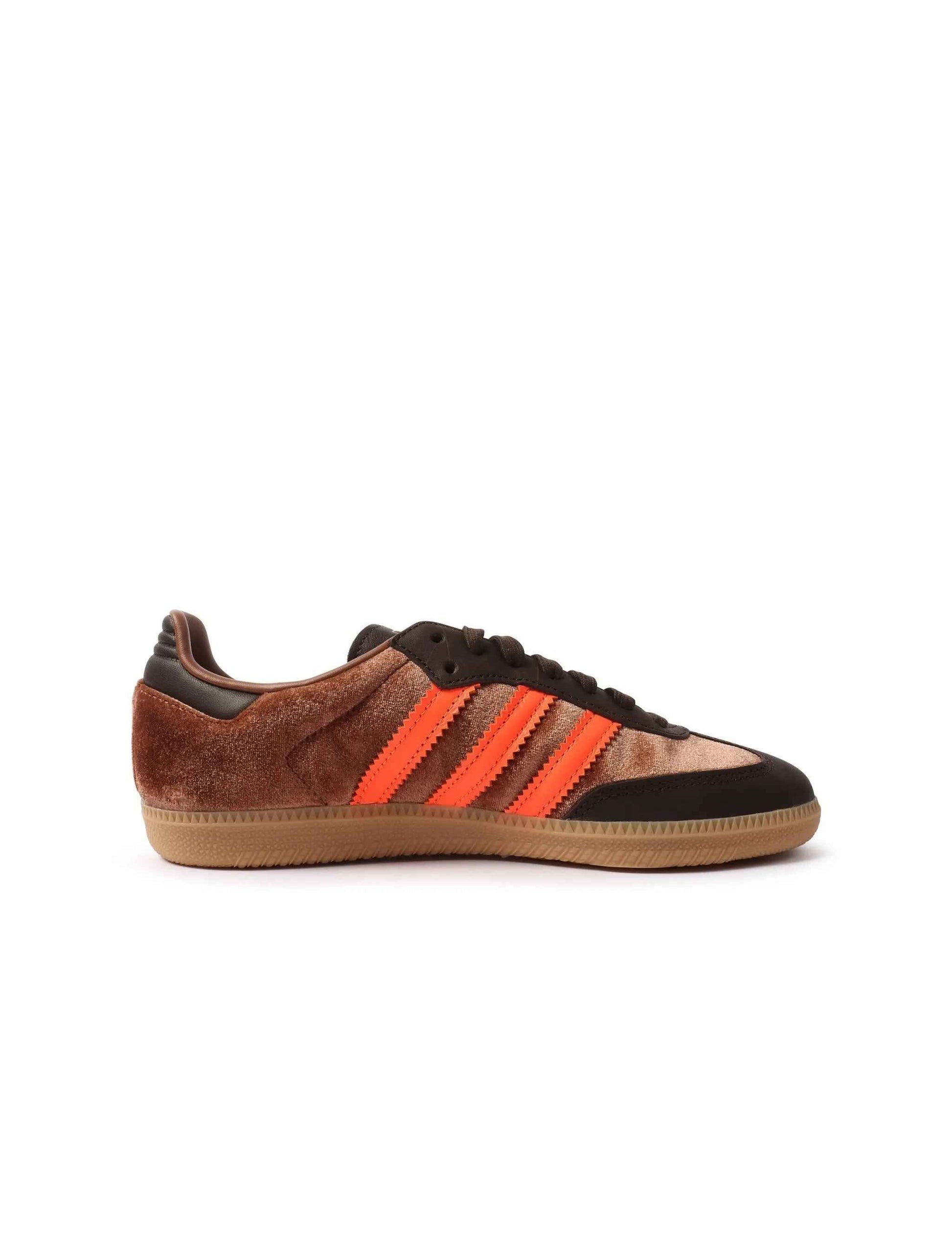 Adidas Samba women's sneakers in luxe brown leather, stylish footwear with classic design and white sole, on a wooden background.