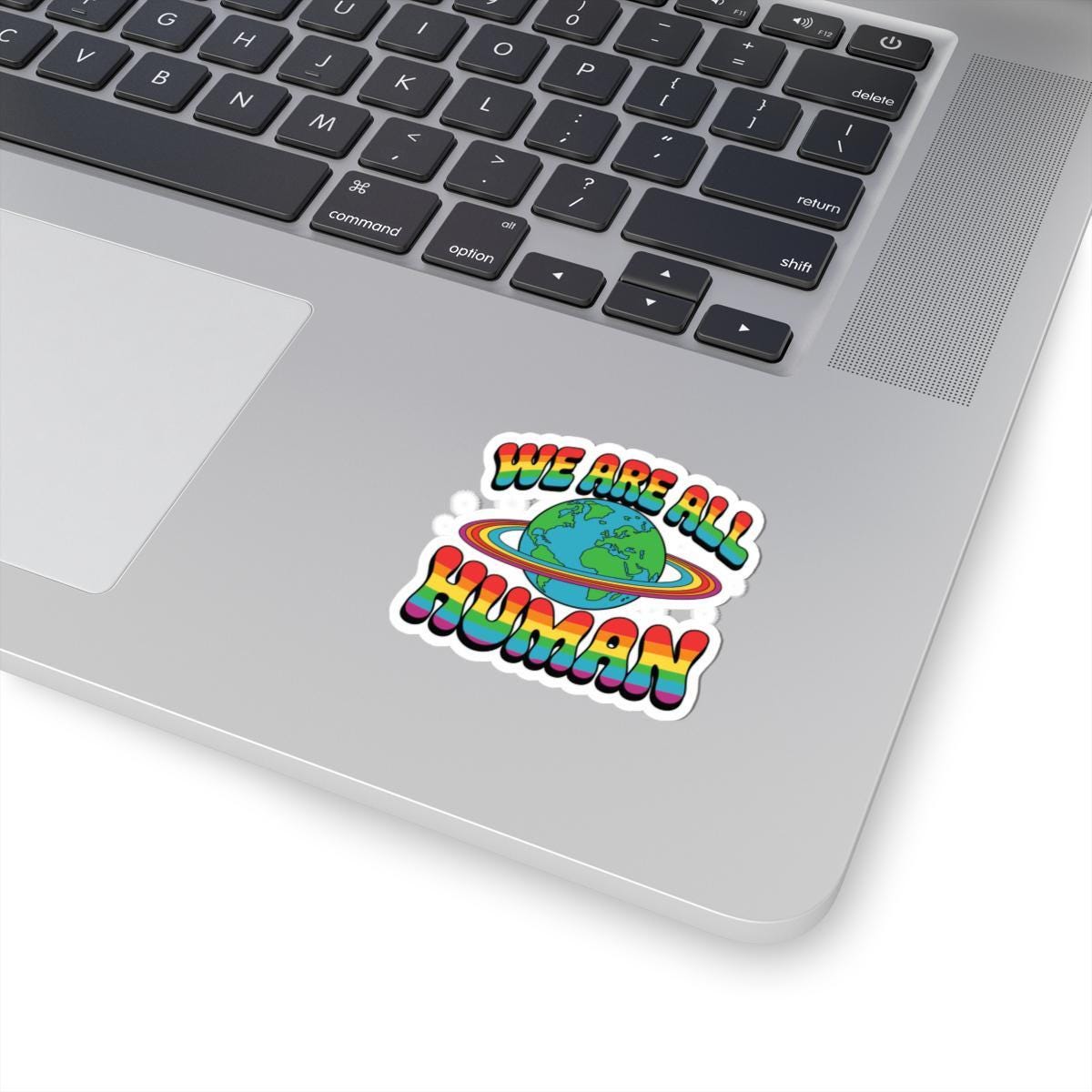Rainbow Earth pride sticker featuring "We Are All Human" message, LGBTQ+ vinyl decal on glossy finish.