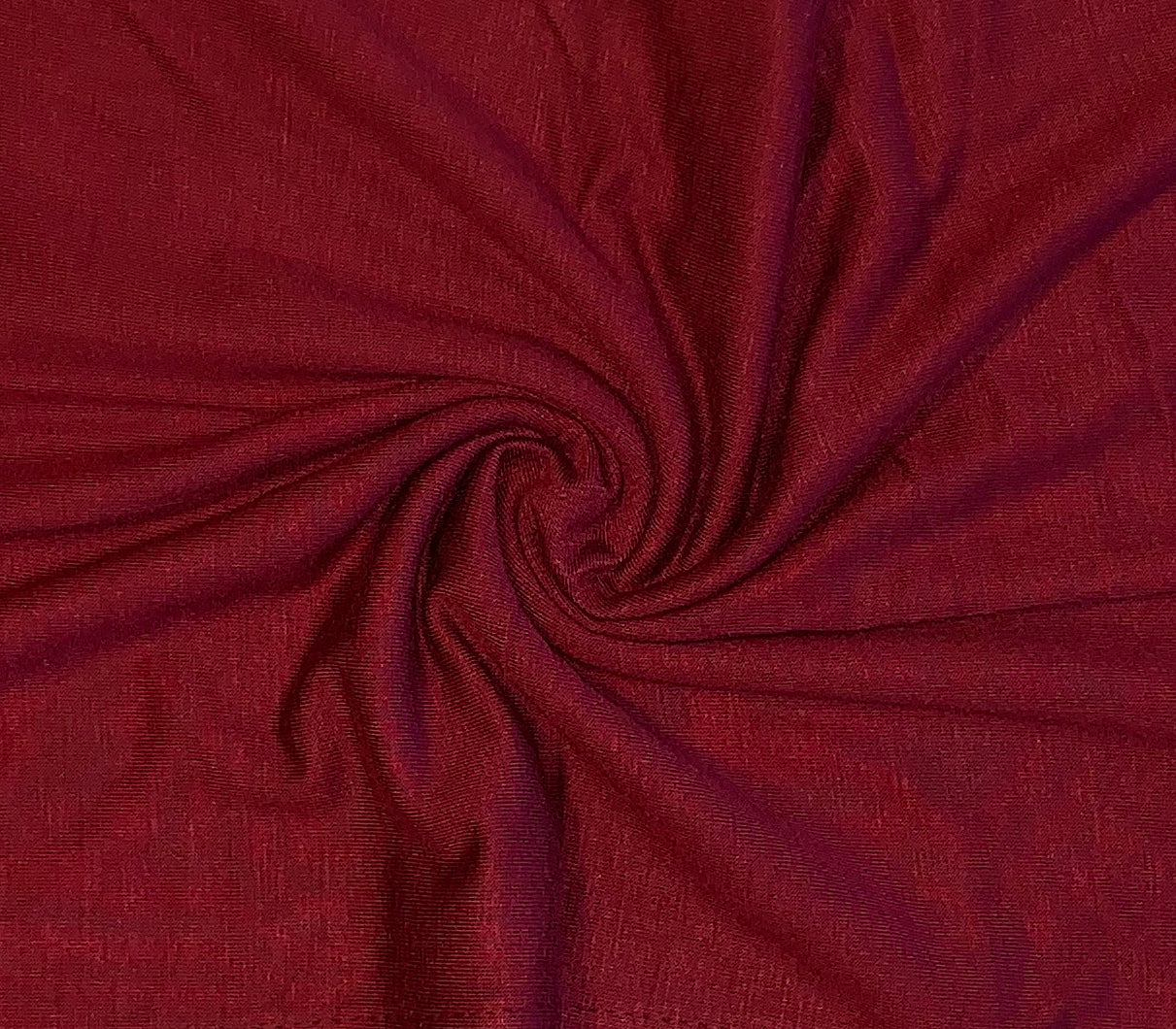 Maroon cotton jersey hijab from Muslimah.de displayed flat, showcasing its soft fabric and rectangular shape.