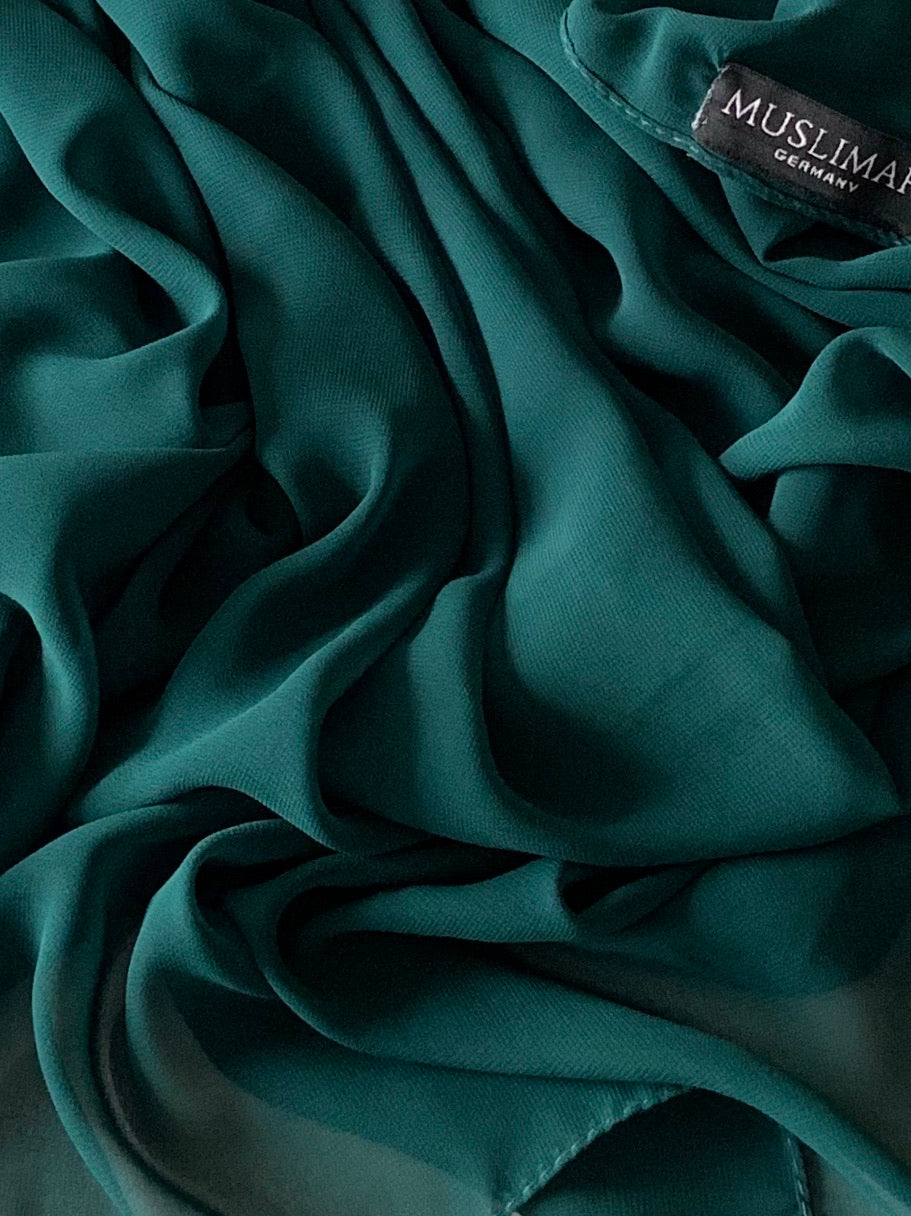 Hunter green premium chiffon hijab from Muslimah.de displayed on a mannequin, showcasing lightweight, elegant fabric and drape.