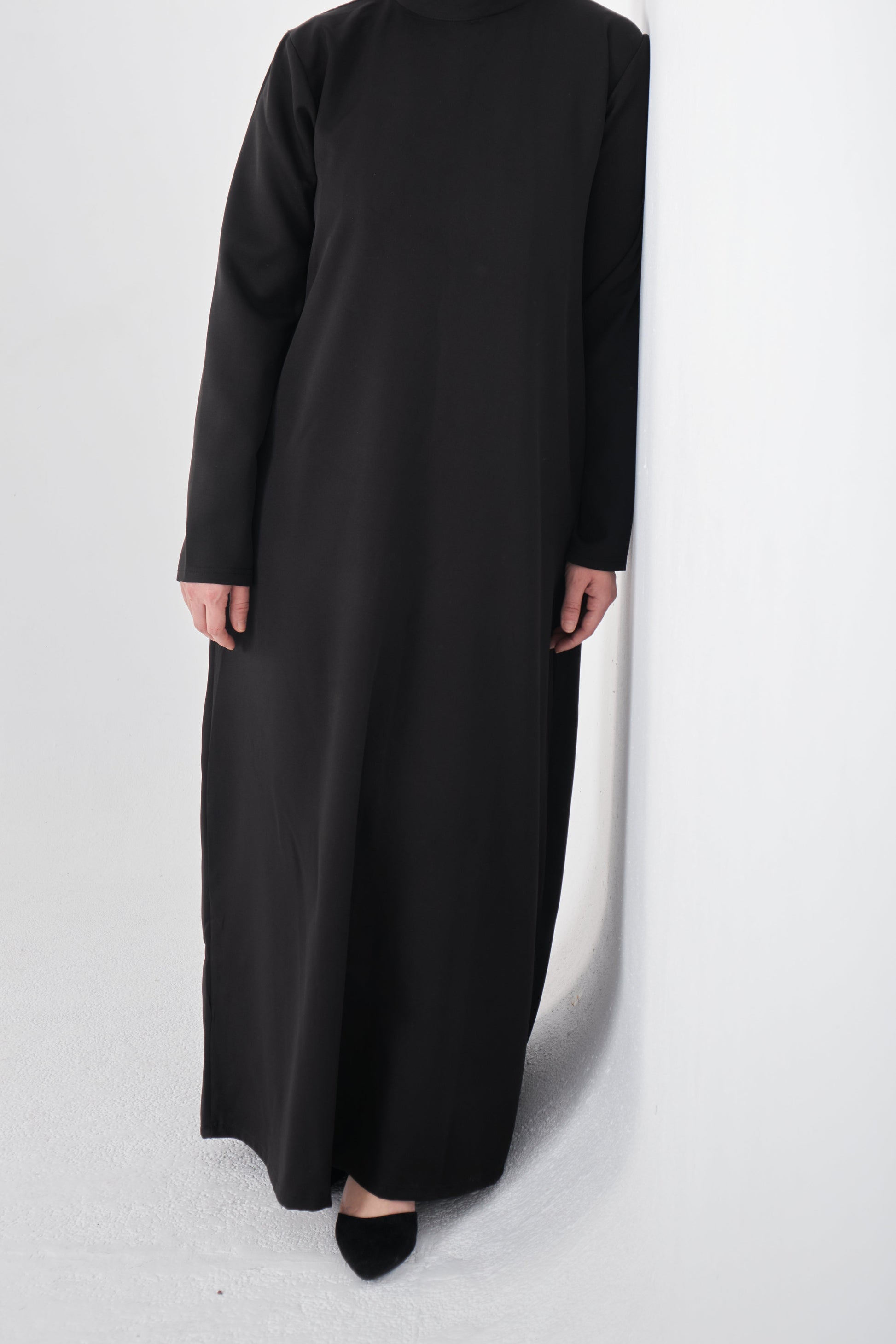 Black basic dress from Muslimah.de, simple and modest style, featuring long sleeves and a round neckline.