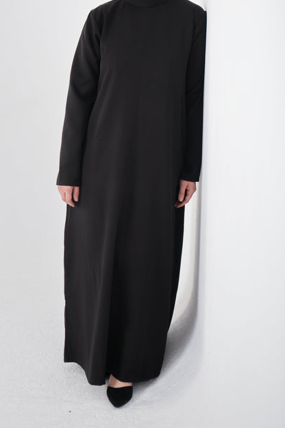 Black basic dress from Muslimah.de, simple and modest style, featuring long sleeves and a round neckline.
