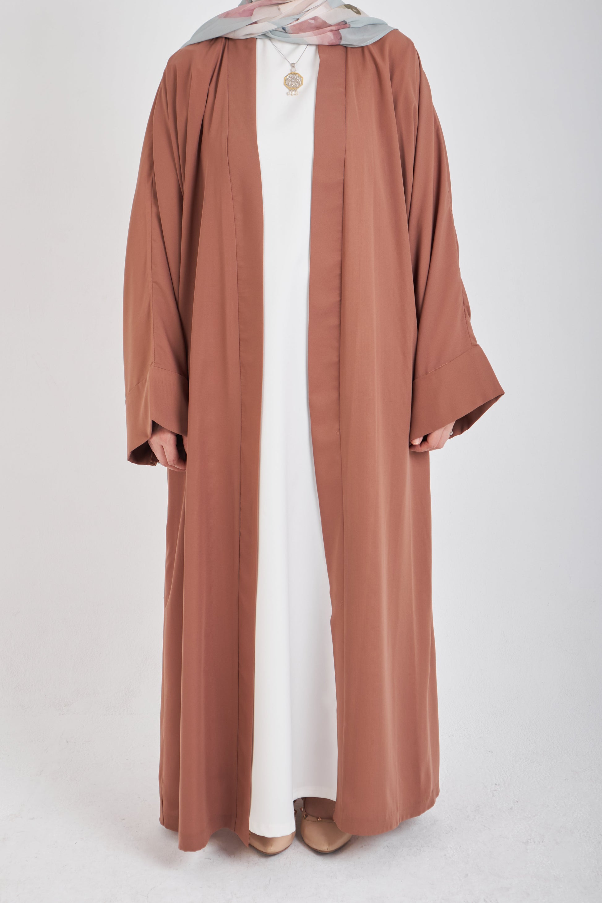 Brown kimono with loose fit and long sleeves, lightweight fabric, from Muslimah.de, shown hanging on a neutral background.