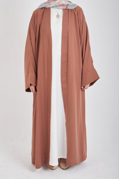 Brown kimono with loose fit and long sleeves, lightweight fabric, from Muslimah.de, shown hanging on a neutral background.