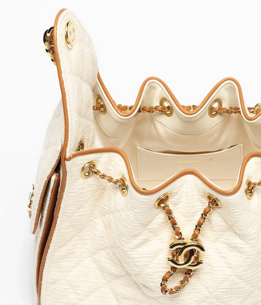Chanel canvas and calfskin gold-tone bag in ecru and camel tones, showcasing a luxurious, structured handbag with gold hardware.