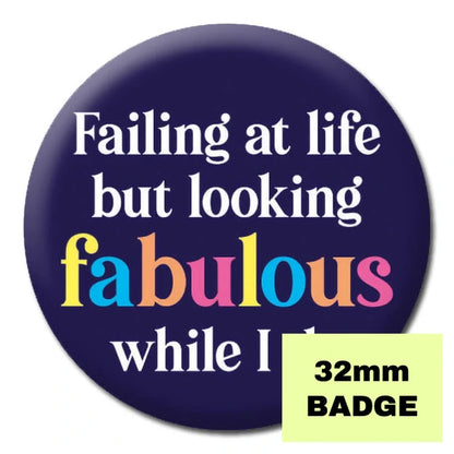 Pink badge from Proud Supplies with the phrase "Failing At Life But Looking Fabulous" in bold lettering.