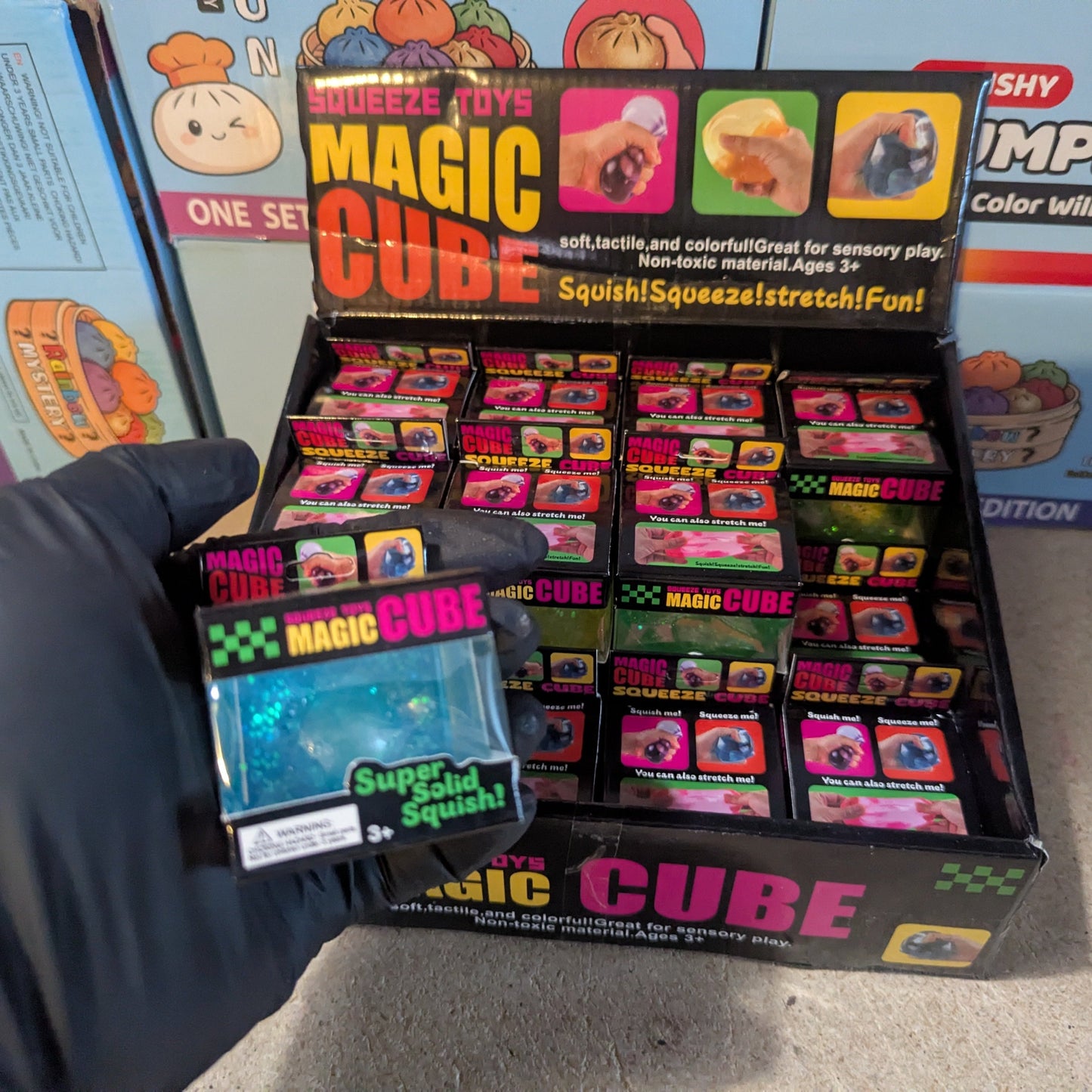 Blue translucent glitter mini magic cube by Squeeze Toys, slow-rising squish toy with shiny glitter and soft, squeezable texture.