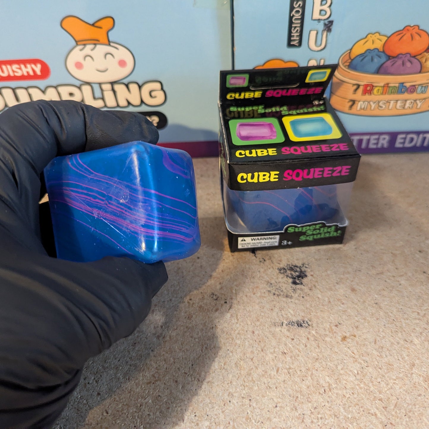 Blue and purple swirl squeeze cube from Ralphie's Funhouse, super slow-rising squish toy for stress relief and sensory play.