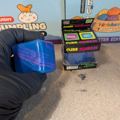 Blue and purple swirl squeeze cube from Ralphie's Funhouse, super slow-rising squish toy for stress relief and sensory play.