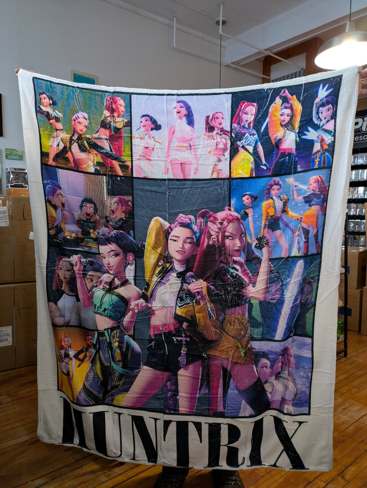 K-POP DEMON HUNTERS HUNTRIX collage blanket featuring vibrant images of Demon Hunters characters on soft fabric.