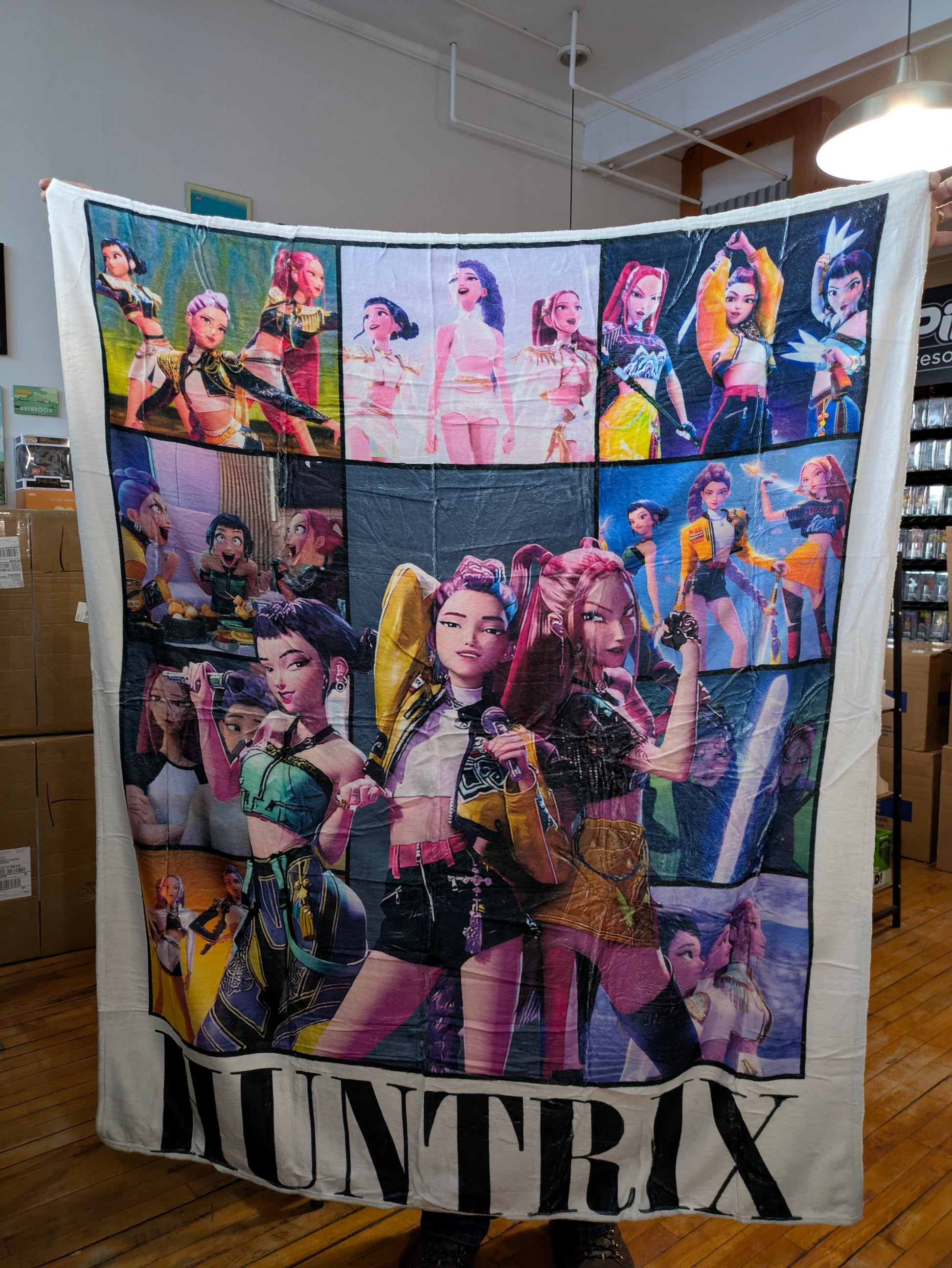 K-POP DEMON HUNTERS HUNTRIX collage blanket featuring vibrant images of Demon Hunters characters on soft fabric.