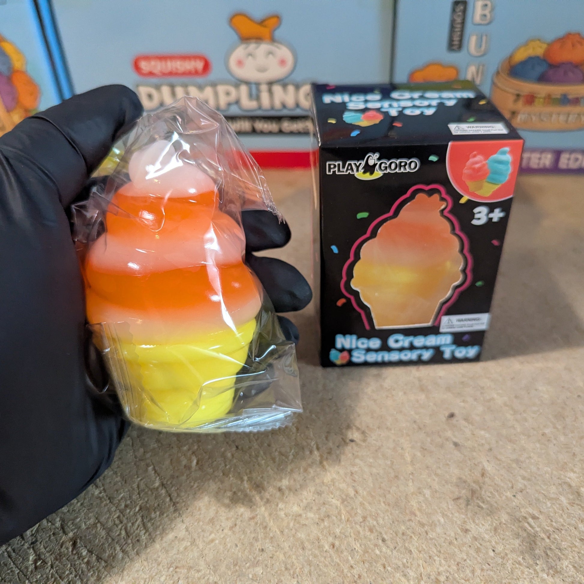 Orange and white swirl ice cream cone squishy from Ralphie's Funhouse, soft gelatin texture, realistic dessert look.