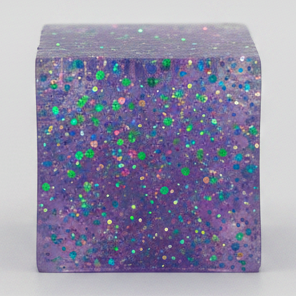Purple translucent glitter mini magic cube by Squeeze Toys, slow-rising squish toy from Ralphie's Funhouse.