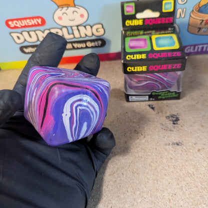 Purple and pink swirl squeeze cube from Ralphie's Funhouse, super slow-rising squish toy with vibrant colors and textured surface.