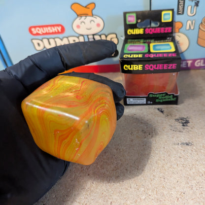 Yellow and orange swirl squeeze cube from Ralphie's Funhouse, a super slow-rising squishy stress relief toy.