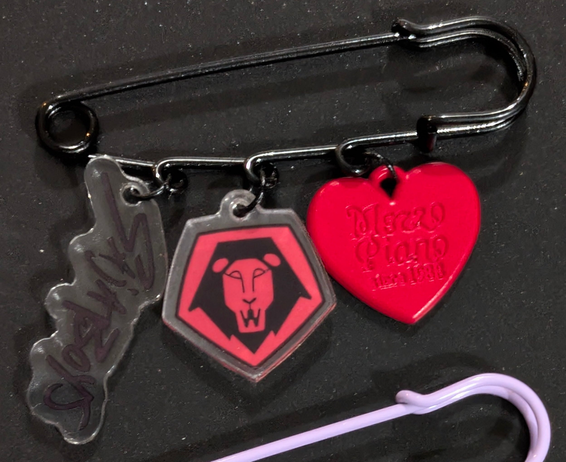 K-POP Demon Hunters safety pin charm featuring Ralphie's Funhouse logo and detailed demon hunter design on metal pin.