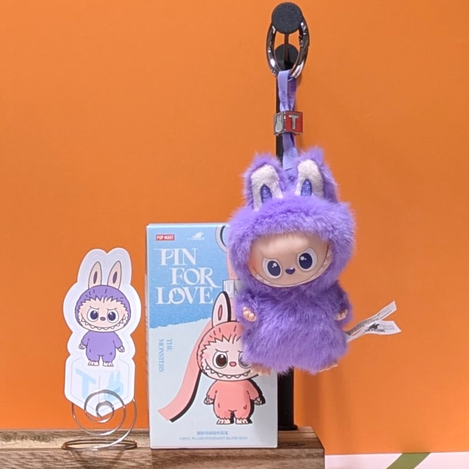 Sealed blind box featuring Ralphie's Funhouse Labubu pin for love, with colorful letter design and collectible charm.