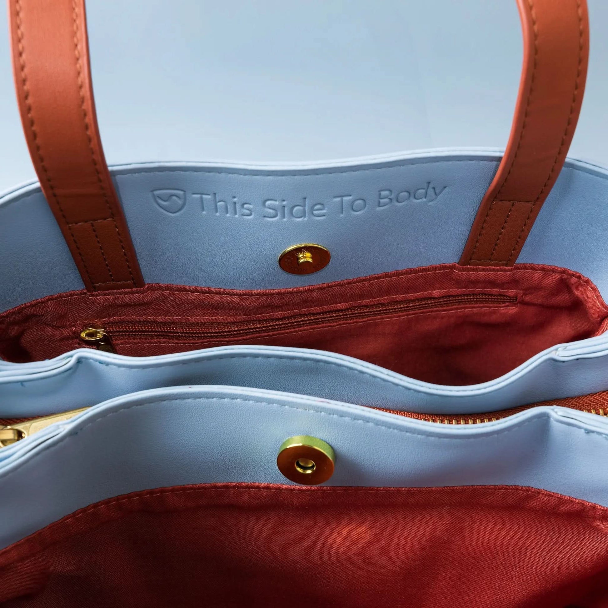 Shield Your Body SYB purse for mobile phones, compact black accessory with zipper closure and branding, designed for phone protection.