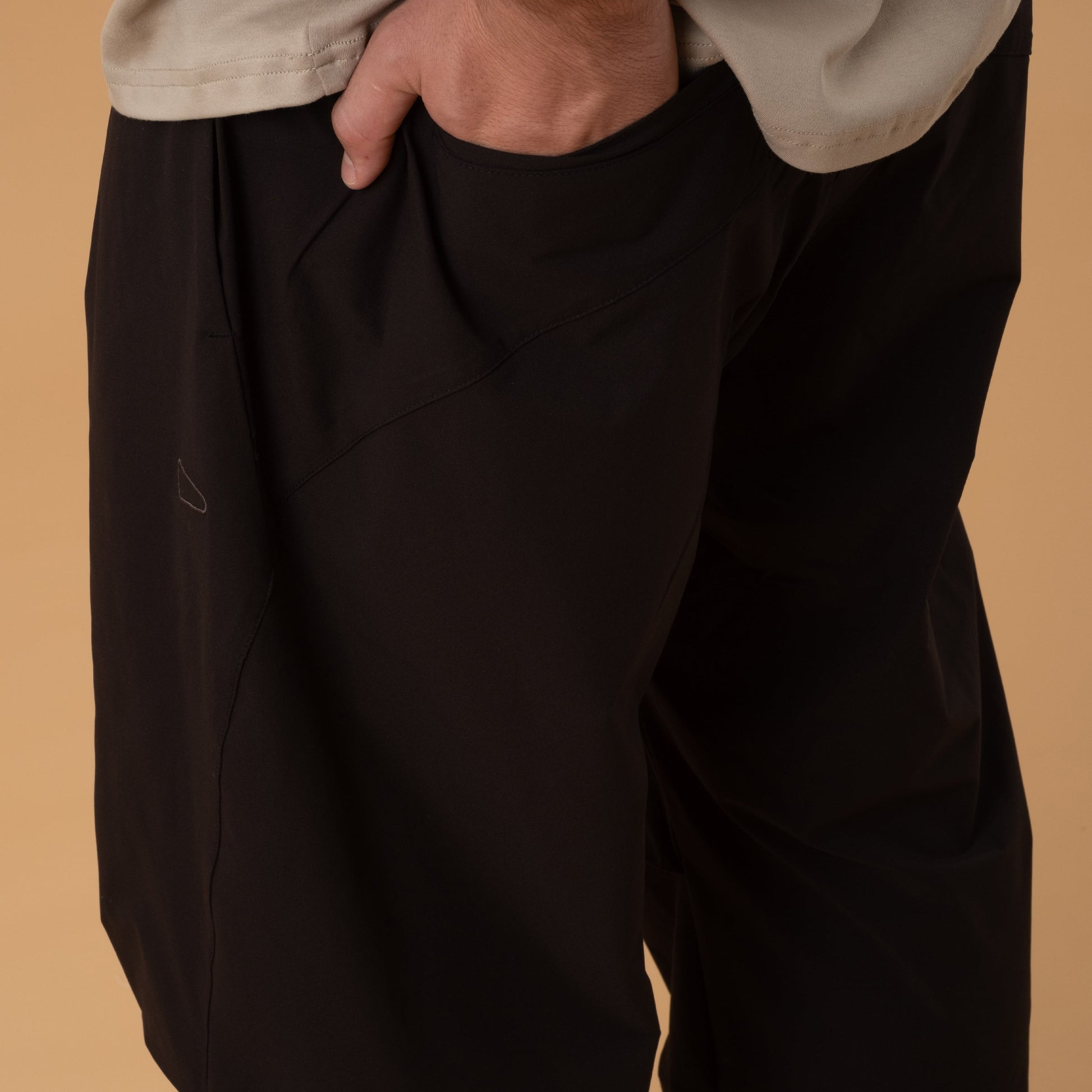 Black pleated field pants by Shuren Projects made of Teflon™ polyester, featuring a relaxed fit and multiple pockets.