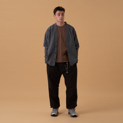 Black pleated field pants by Shuren Projects made from Teflon™ polyester, designed as durable and stylish bottoms.