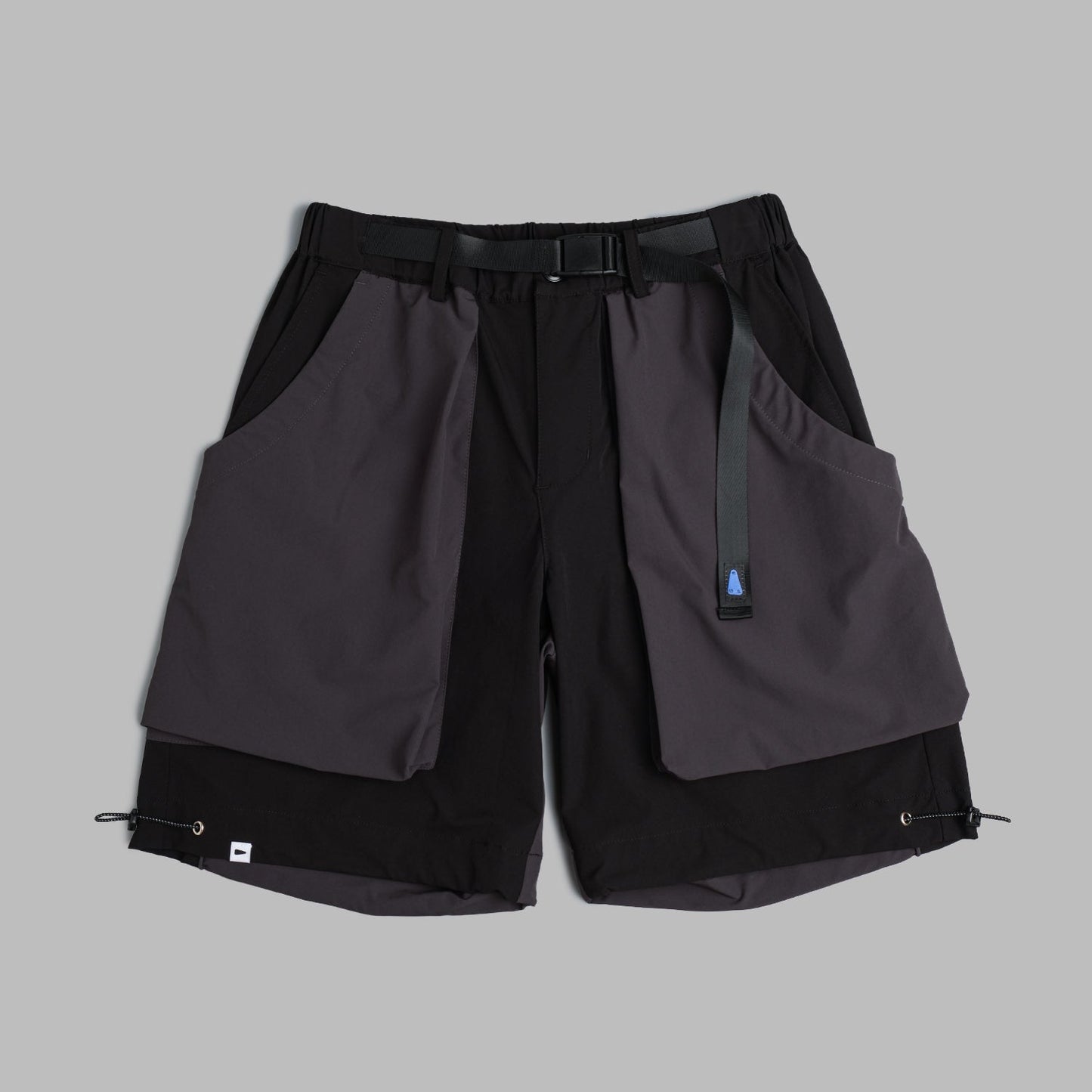 Black Shuren Projects camping shorts made of 2-tone nylon, shown laid flat with pockets and adjustable waistband.