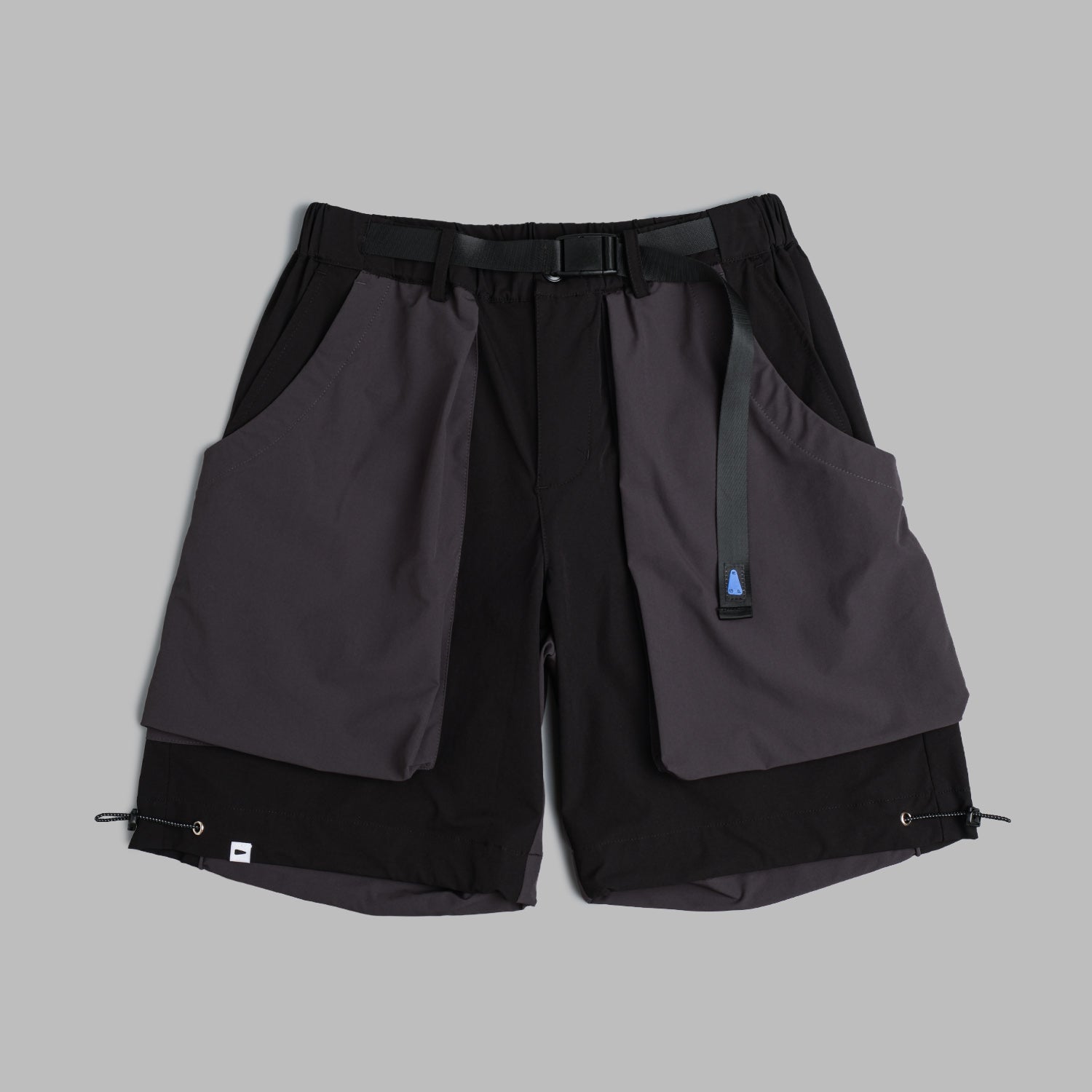 Black Shuren Projects camping shorts made of 2-tone nylon, shown laid flat with pockets and adjustable waistband.