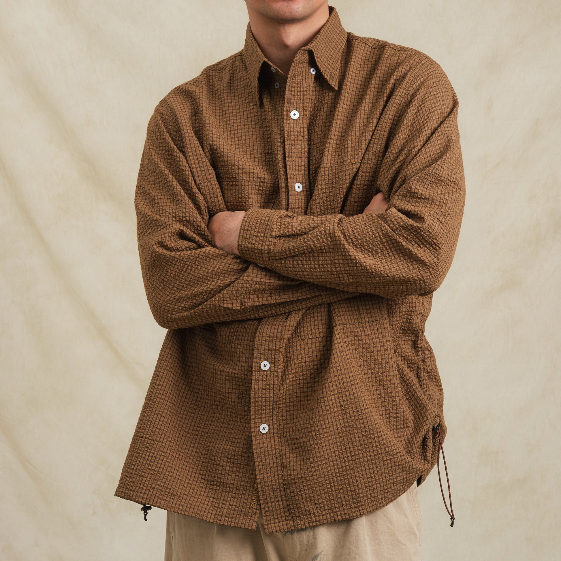 Brown checkered sidepull shirt made from seersucker cotton by Shuren Projects, showing the button-up front and collar detail.