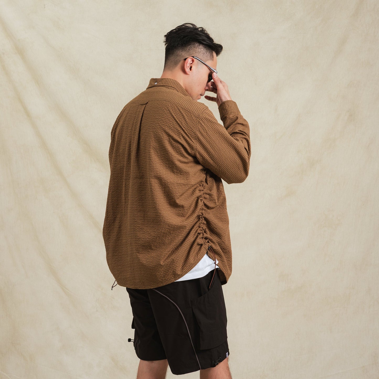 Brown checkered sidepull shirt made from seersucker cotton by Shuren Projects, showcasing a casual, textured fabric design.