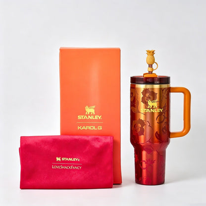 Orange STANLEY Quencher H2.0 FlowState tumbler with black lid, designed for hot and cold beverages, featuring durable stainless steel construction.