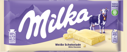Sweet Palace Milka chocolates in alpine milk flavor, showing a pile of creamy, milk chocolate candies with purple packaging.