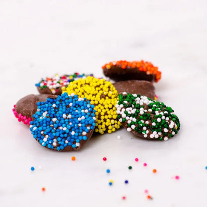 Colorful Sweet Palace candy nonpareils in a clear jar, showing tiny round sugar sprinkles perfect for decorating desserts.
