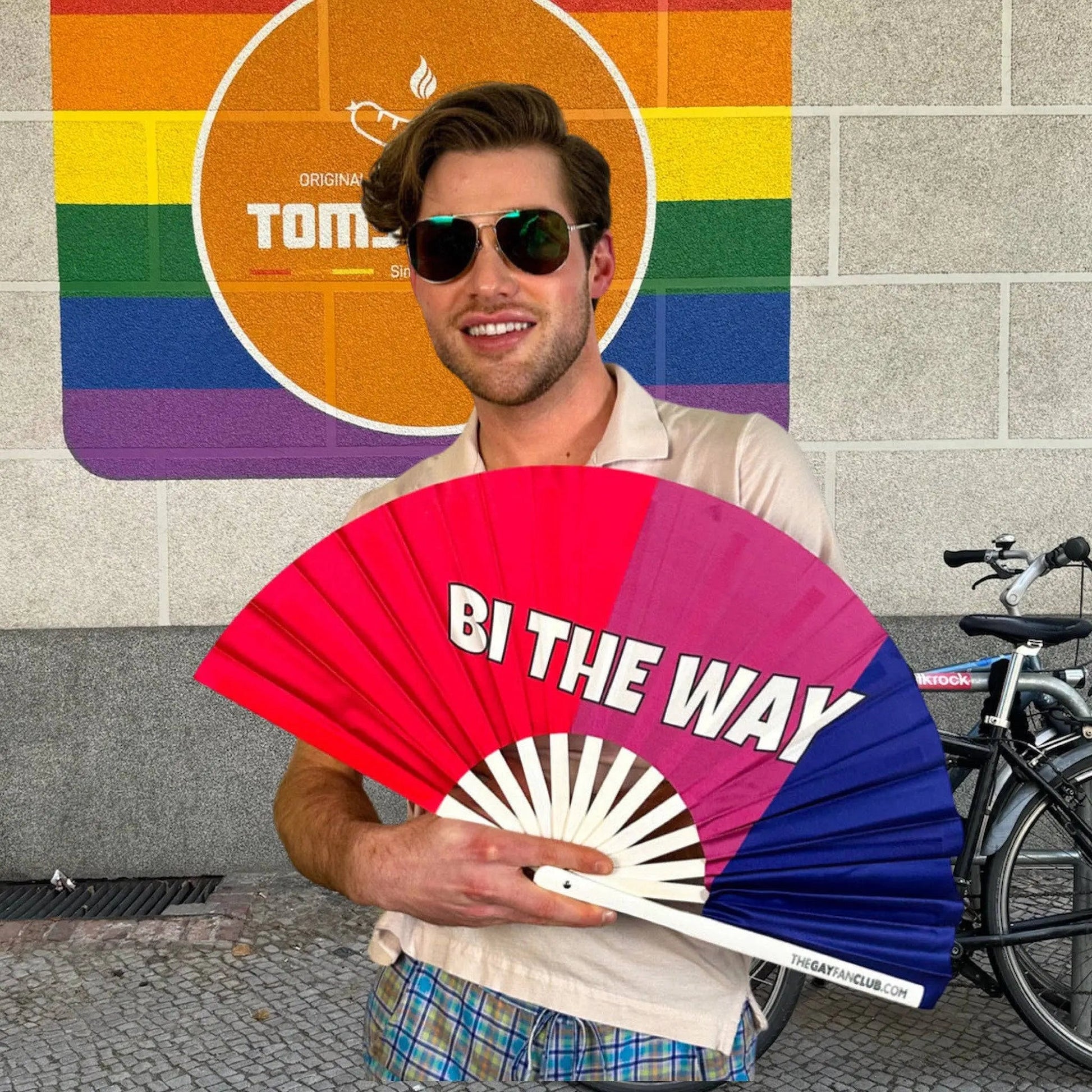 Hand fan from The Gay Fan Club featuring the Bi the Way design, with colorful graphics and a lightweight, portable structure.