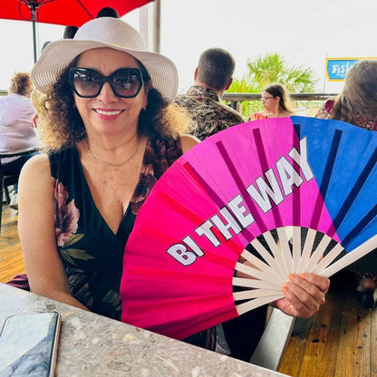 Hand fan from The Gay Fan Club featuring the "Bi the Way" design, colorful and portable for easy cooling and style.