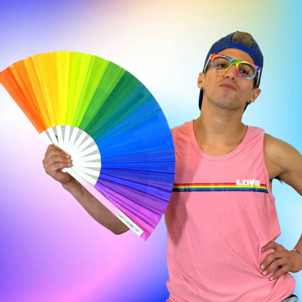 Colorful rainbow hand fan by The Gay Fan Club, featuring vibrant rainbow stripes and a lightweight, foldable design.