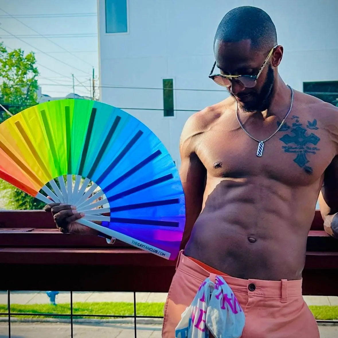 Colorful Over The Rainbow hand fan by The Gay Fan Club featuring vibrant rainbow stripes and lightweight wooden handles.