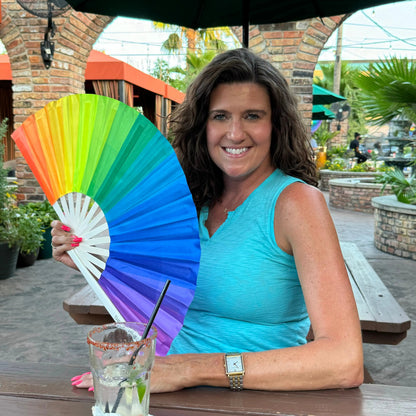 Colorful over the rainbow hand fan by The Gay Fan Club with vibrant rainbow design and wooden handle.