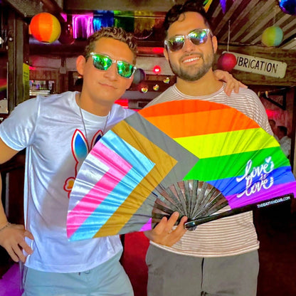 Hand fan featuring a vibrant rainbow pride flag design by The Gay Fan Club. Bright, colorful, and perfect for celebrations.