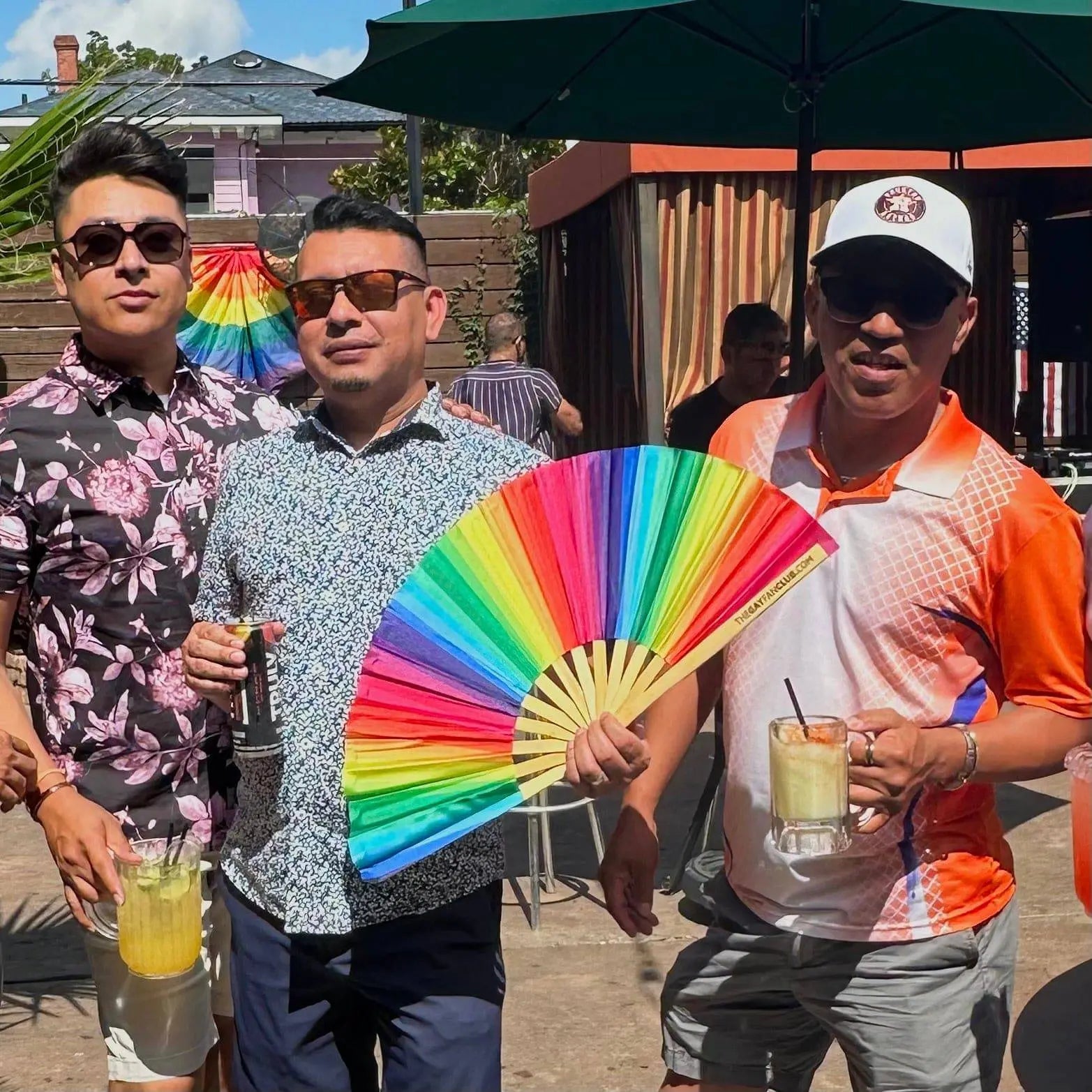 Rainbow folding hand fan by The Gay Fan Club with vibrant rainbow-colored fabric and compact folding design.