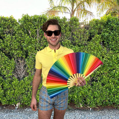 Rainbow folding hand fan by The Gay Fan Club featuring vibrant rainbow colors and a compact, foldable design.