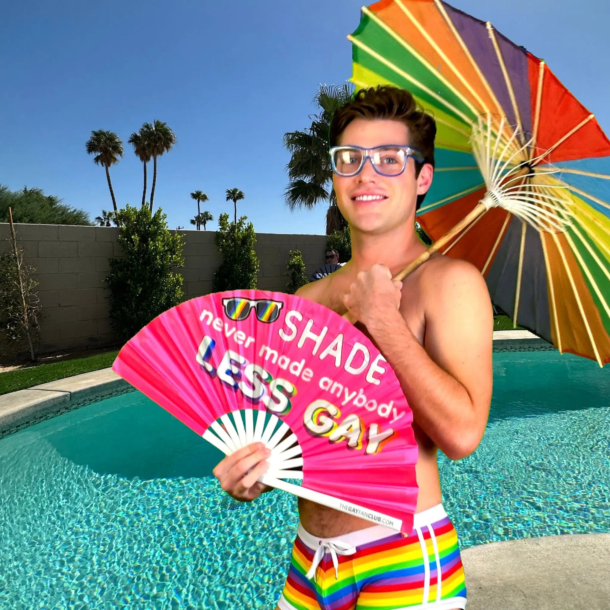 Hand fan from The Gay Fan Club featuring the "Shade Never Made Anybody Less Gay" design, with colorful printed text on fabric.