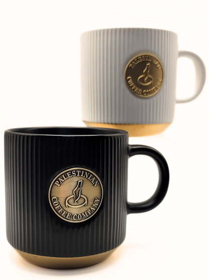 Black ceramic mug from Pali Coffee Co by The Palestinian Coffee Company, with a simple, sleek design and the brand logo.