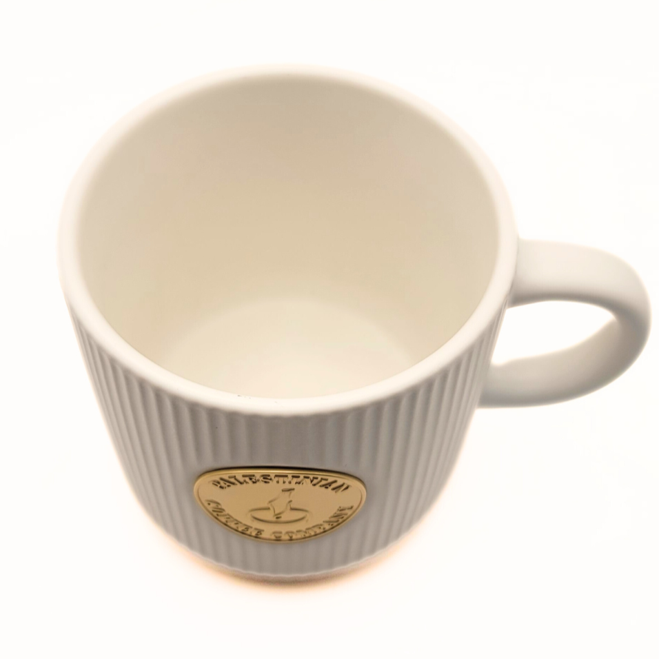 Black ceramic mug from The Palestinian Coffee Company with Pali Coffee Co branding, ideal for hot beverages.