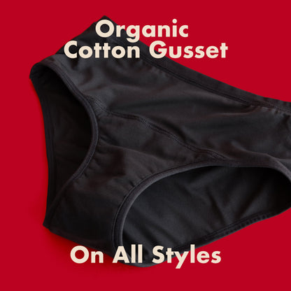 Black microfiber bikini-style menstrual pad by The Period Company for medium flows, shown in a close-up image.