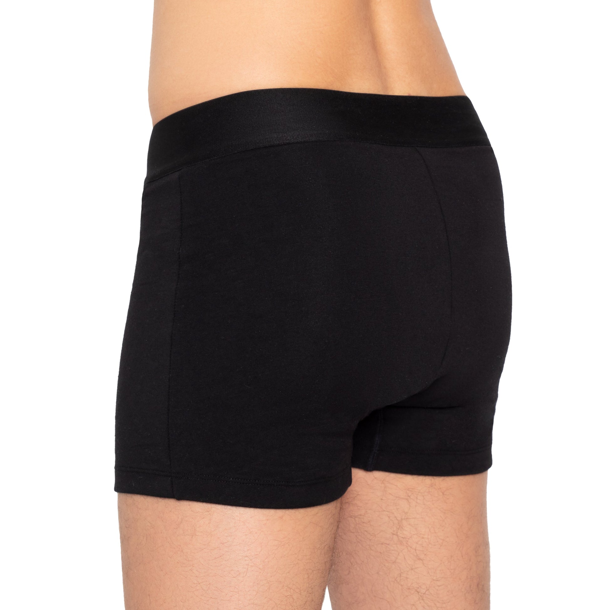 Black organic cotton boxer underwear by The Period Company, designed for heavy flows, shown on a model.