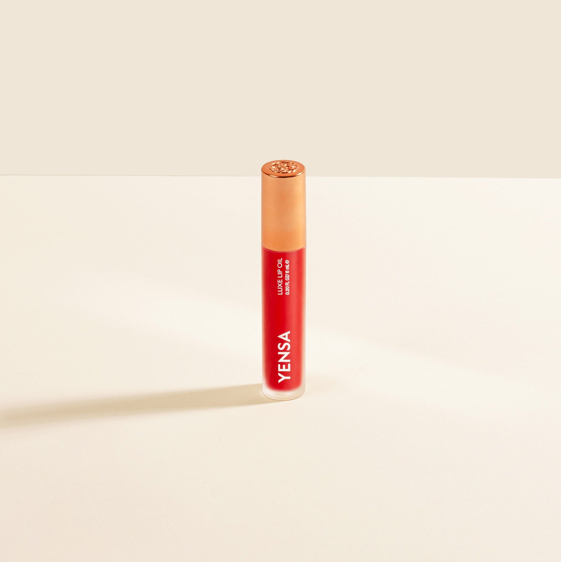 YENSA Luxe Lip Nourishing Oil with Hyaluronic and Vitamin E, featuring a glossy lip oil in a sleek bottle with a red tint.