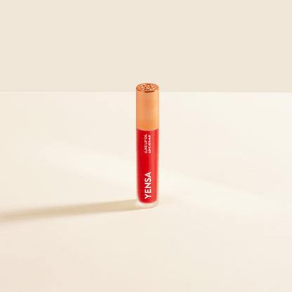 YENSA Luxe Lip Nourishing Oil with Hyaluronic and Vitamin E, featuring a glossy lip oil in a sleek bottle with a red tint.